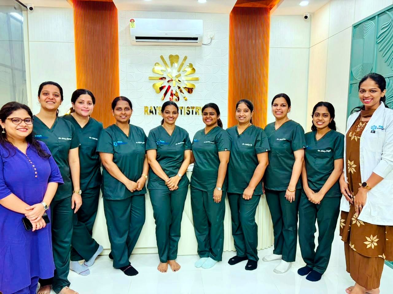 The team of dentists at Rays Kids Dentistry and Family Dental Care in front of the clinic logo, Sarjapur Bengaluru